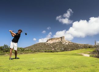 Een man die aan het golfen is bij de Oude Steengroeve op de Santa Barbara Plantage op Curaçao.